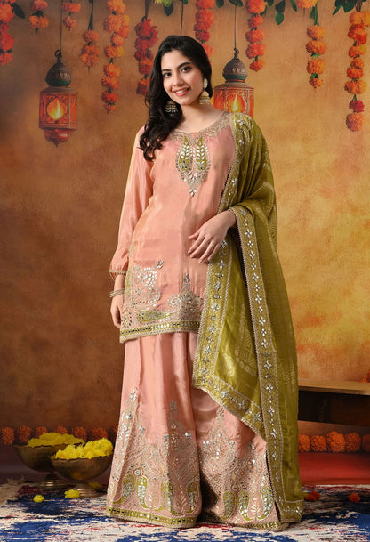 Peach Tissue Crepe Sharara Set with intricate gotta, zardozi, applique, and mirror work, paired with a contrasting green Banarasi silk dupatta