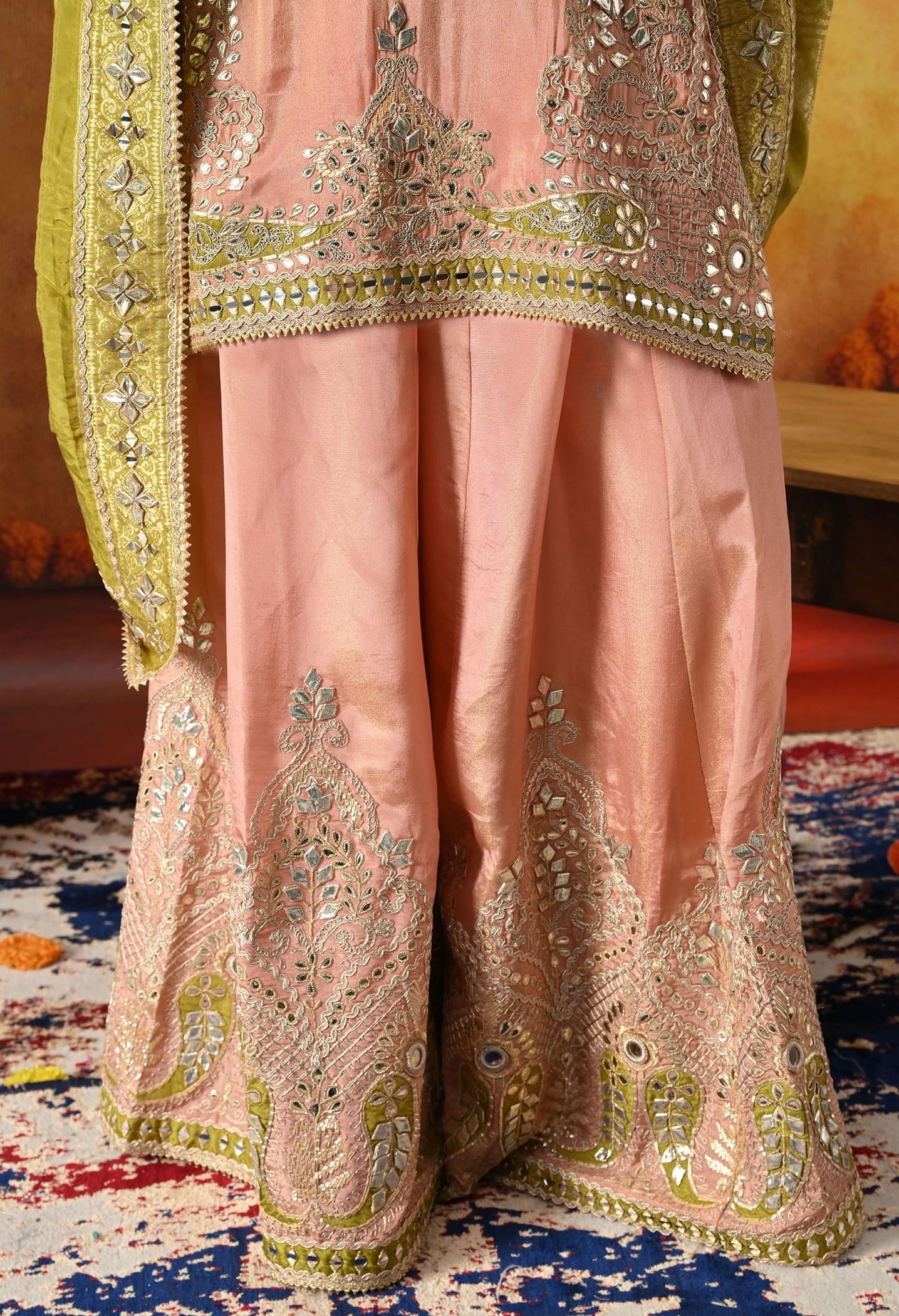 Peach Tissue Crepe Sharara Set with intricate gotta, zardozi, applique, and mirror work, paired with a contrasting green Banarasi silk dupatta