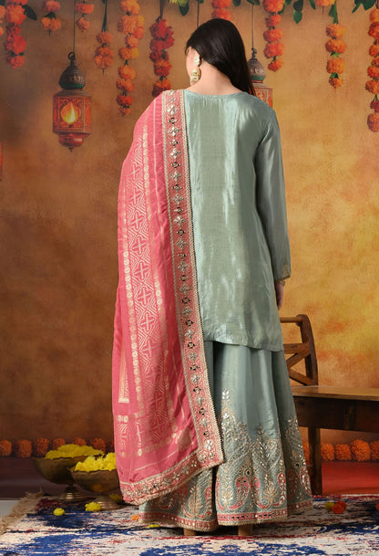 Elegant light blue sharara set in tissue crepe with gotta, zardozi, and mirror work, paired with a contrasting pink Banarasi silk dupatta