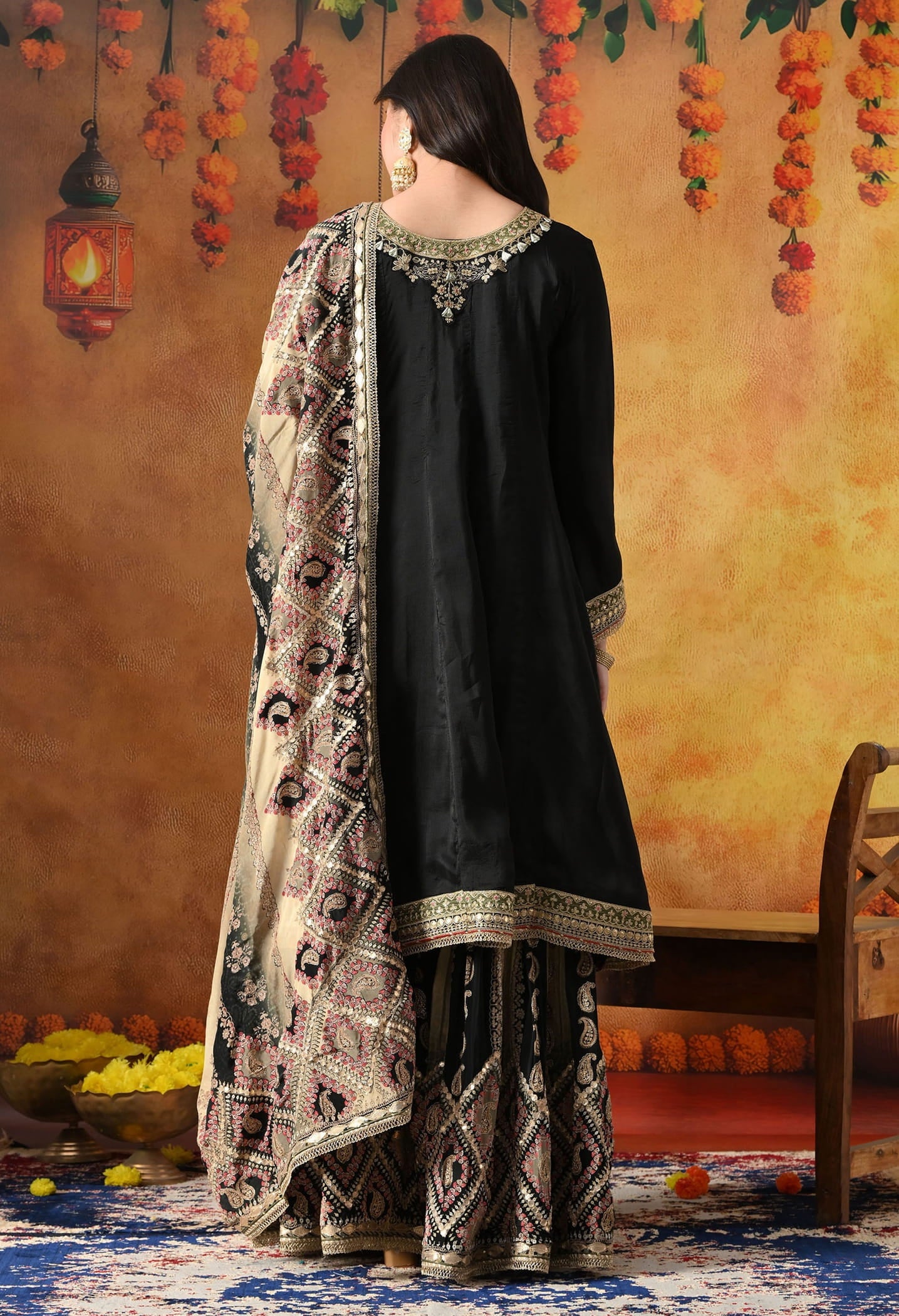 Elegant black gharara set in crepe with gotta, zardozi, and sequin work, paired with a printed gharara and dupatta