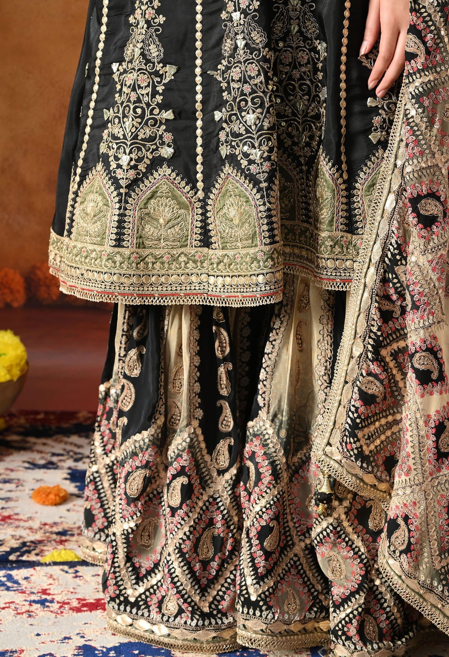 Elegant black gharara set in crepe with gotta, zardozi, and sequin work, paired with a printed gharara and dupatta