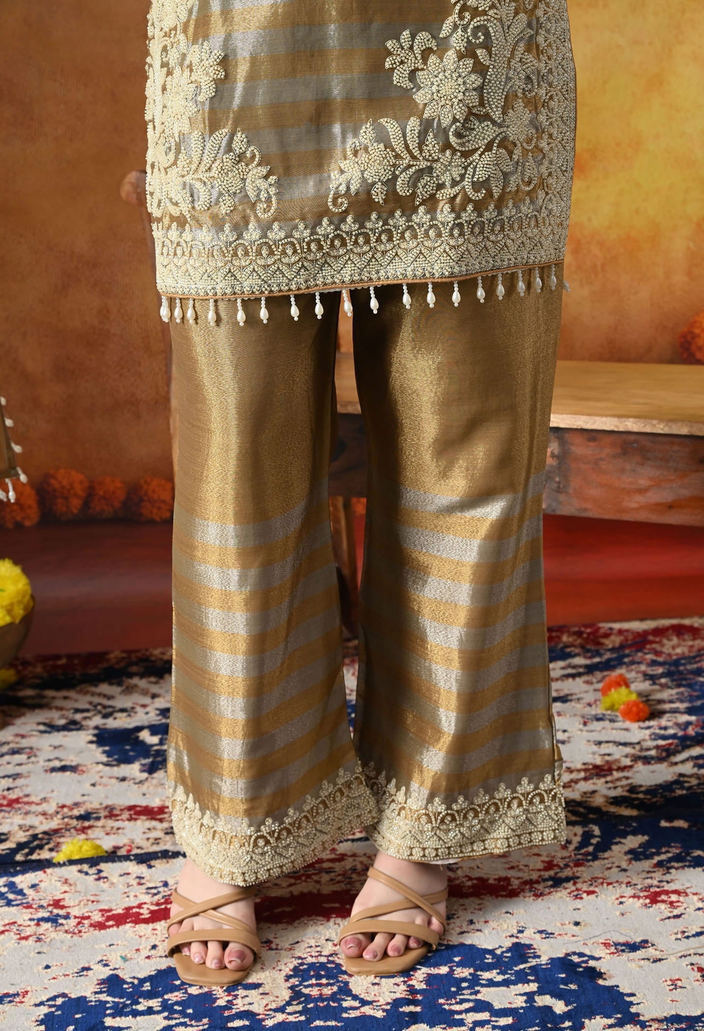 Elegant golden kurta set in tissue silk with thread and pearl work, paired with straight pants and matching dupatta