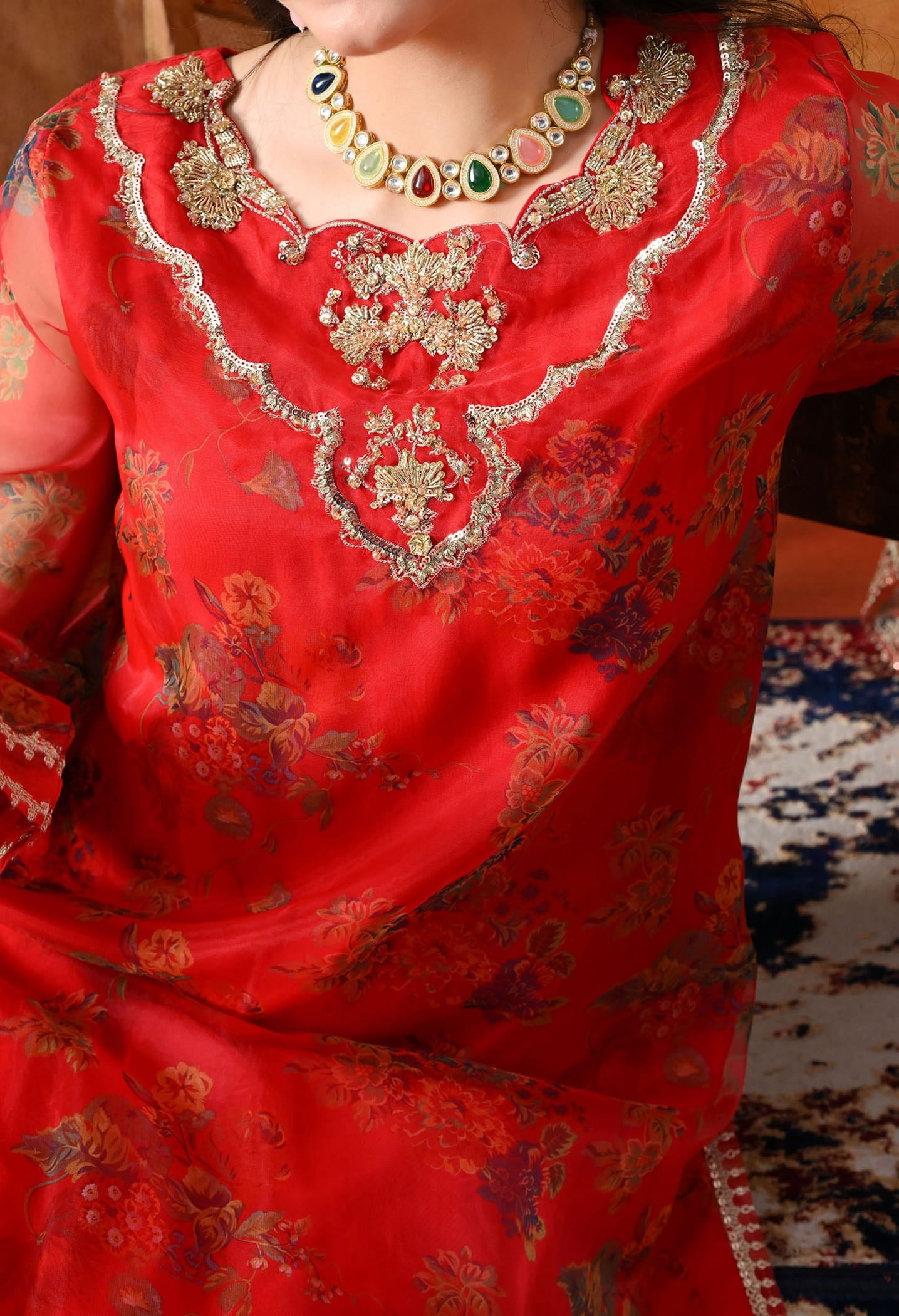 Elegant red kurta set in organza featuring intricate zardozi and sequin work, paired with a graceful farshi salwar and matching dupatta